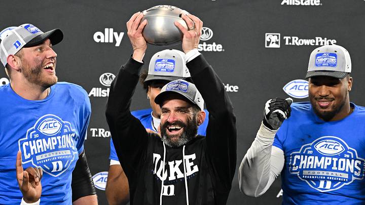Dec 6, 2025; Charlotte, NC, USA; Duke Blue Devils head coach Manny Diaz lifts the ACC trophy with offensive lineman Justin Pickett (77) and defensive tackle Aaron Hall (99) after defeating the Virginia Cavaliers at the 2025 ACC Championship game at Bank of America Stadium. Mandatory Credit: Bob Donnan-Imagn Images