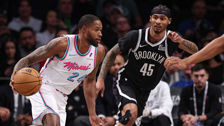 Feb 7, 2025; Brooklyn, New York, USA; Miami Heat forward Haywood Highsmith (24) dribbles as Brooklyn Nets guard Keon Johnson (45) defends during the first quarter at Barclays Center. Mandatory Credit: Vincent Carchietta-Imagn Images