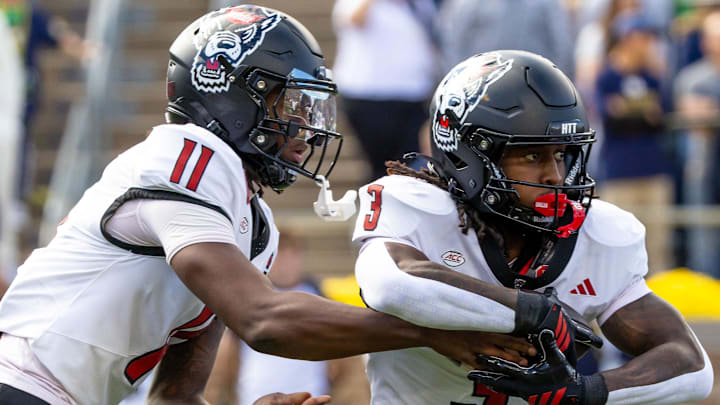 Oct 11, 2025; South Bend, Indiana, USA; NC State Wolfpack quarterback CJ Bailey (11) hands off to NC State Wolfpack running back Hollywood Smothers (3) during the first half at Notre Dame Stadium. Mandatory Credit: Michael Caterina-Imagn Images