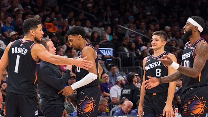 Nov 2, 2025; Phoenix, Arizona, USA; Phoenix Suns guard Devin Booker (1), forward Ryan Dunn (0), Coach Jordan Ott, guard Grayson Allen (8), forward Royce O'Neale (00) and center Mark Williams (15) celebrate during a time-out in the second half against the San Antonio Spurs at Mortgage Matchup Center. Mandatory Credit: Allan Henry-Imagn Images