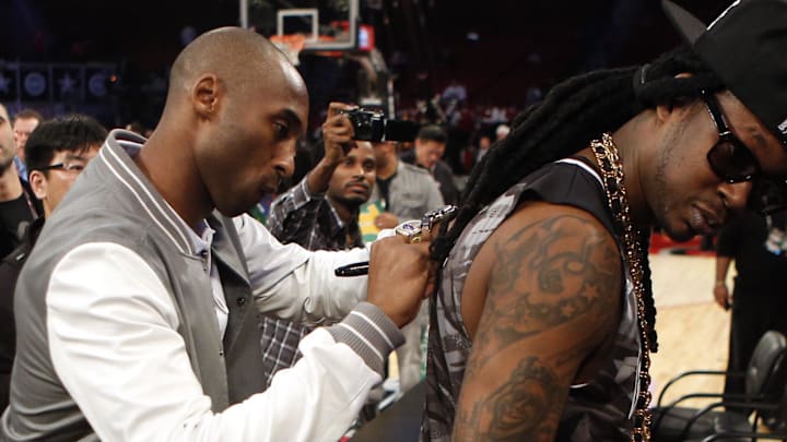 Feb 16, 2013; Houston, TX, USA; Los Angeles Lakers player Kobe Bryant (left) signs the shirt of recording artist 2 Chainz after the 2013 NBA all star slam dunk contest at the Toyota Center. Mandatory Credit: Brett Davis-Imagn Images