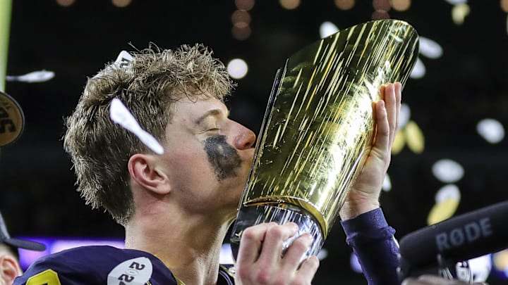 Michigan quarterback J.J. McCarthy kisses the trophy to celebrate winning the national championship game.