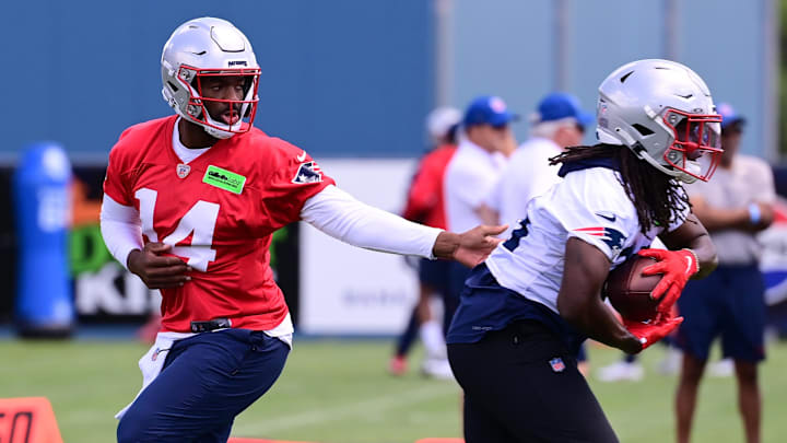 Jun 10, 2024; Foxborough, MA, USA;  New England Patriots quarterback Jacoby Brissett (14) hands the ball to running back Rhamondre Stevenson (38) at minicamp at Gillette Stadium. Mandatory Credit: Eric Canha-USA TODAY Sports