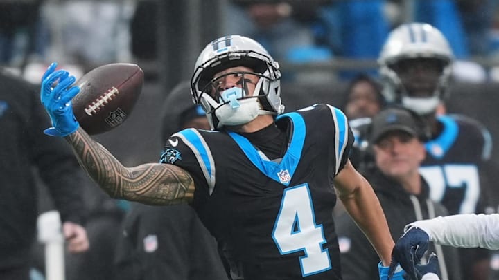 Dec 28, 2025; Charlotte, North Carolina, USA; Carolina Panthers wide receiver Tetairoa McMillan (4) extends for a pass thrown by quarterback Bryce Young (not pictured) against Seattle Seahawks cornerback Devon Witherspoon (21) during the second quarter at Bank of America Stadium. Mandatory Credit: Jim Dedmon-Imagn Images