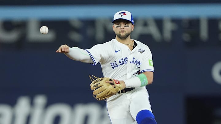 Toronto Blue Jays designated hitter Bo Bichette (11) throws to first for an out against Los Angeles Dodgers right fielder Teoscar Hernandez (37) in the eighth inning during game seven of the 2025 MLB World Series at Rogers Centre. 