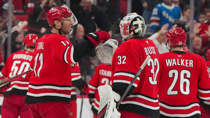 Dec 29, 2025; Raleigh, North Carolina, USA;  Carolina Hurricanes goaltender Brandon Bussi (32) and center Jordan Staal (11) celebrate their victory against the New York Rangers in the overtime at Lenovo Center. Mandatory Credit: James Guillory-Imagn Images