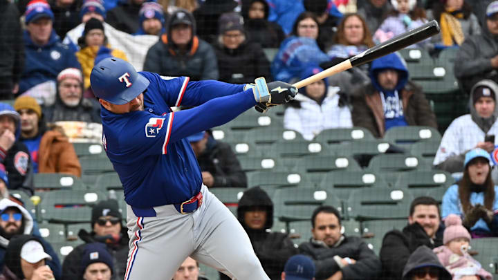 Apr 9, 2025; Chicago, Illinois, USA; Texas Rangers first baseman Jake Burger (21) hits a single during the fourth inning against the Chicago Cubs at Wrigley Field. Apr 9, 2025; Chicago, Illinois, USA; Texas Rangers first baseman Jake Burger (21) hits a single during the fourth inning against the Chicago Cubs at Wrigley Field.