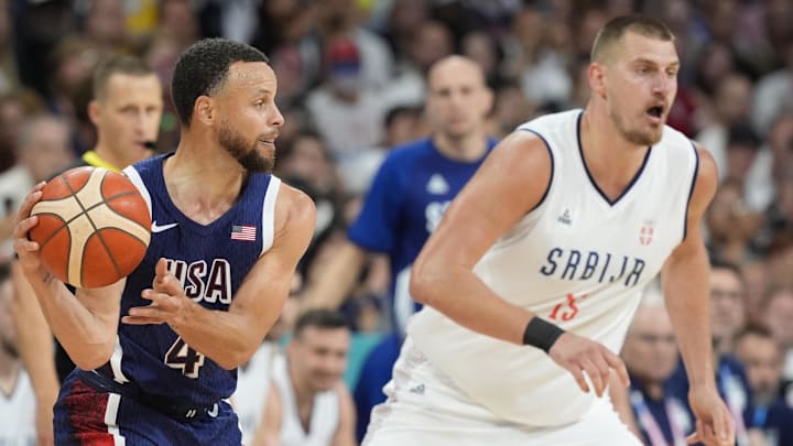 Jul 28, 2024; Villeneuve-d'Ascq, France; United States shooting guard Stephen Curry (4) passes against Serbia power forward Nikola Jokic (15) in the fourth quarter during the Paris 2024 Olympic Summer Games at Stade Pierre-Mauroy. Jul 28, 2024; Villeneuve-d'Ascq, France; United States shooting guard Stephen Curry (4) passes against Serbia power forward Nikola Jokic (15) in the fourth quarter during the Paris 2024 Olympic Summer Games at Stade Pierre-Mauroy.