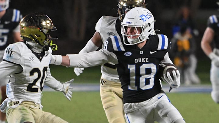 Nov 29, 2025; Durham, North Carolina, USA; Duke Blue Devils wide receiver Cooper Barkate (18) runs the ball against Wake Forest Demon Deacons defensive back Lardarius Webb Jr. (20) during the fourth quarter at Wallace Wade Stadium. Mandatory Credit: Zachary Taft-Imagn Images Nov 29, 2025; Durham, North Carolina, USA; Duke Blue Devils wide receiver Cooper Barkate (18) runs the ball against Wake Forest Demon Deacons defensive back Lardarius Webb Jr. (20) during the fourth quarter at Wallace Wade Stadium. Mandatory Credit: Zachary Taft-Imagn Images