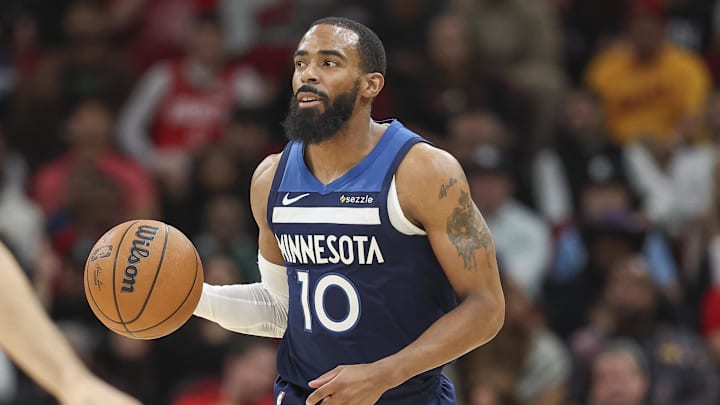 Dec 27, 2024; Houston, Texas, USA; Minnesota Timberwolves guard Mike Conley (10) brings the ball up the court during the first quarter against the Houston Rockets at Toyota Center.