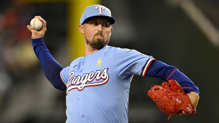 Texas Rangers relief pitcher Shawn Armstrong throws while wearing a blue jersey and blue hat