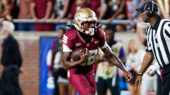 Nov 18, 2023; Tallahassee, Florida, USA; Florida State Seminoles running back Samuel Singleton Jr. (28) runs with the ball past North Alabama Lions defensive back Gregory Reddick (9) during the fourth quarter at Doak S. Campbell Stadium. Mandatory Credit: Morgan Tencza-Imagn Images