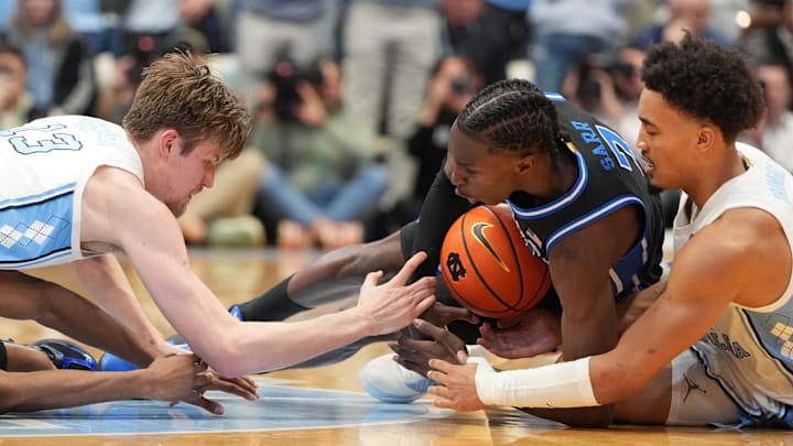 Feb 7, 2026; Chapel Hill, North Carolina, USA;  Duke Blue Devils guard Dame Sarr (7) with the ball as North Carolina Tar Heels center Henri Veesaar (13) and guard Seth Trimble (7) defend in the second  half at Dean E. Smith Center. Mandatory Credit: Bob Donnan-Imagn Images