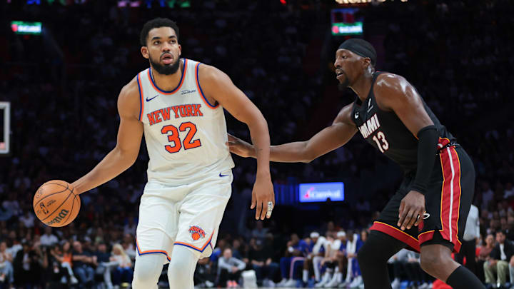 Oct 26, 2025; Miami, Florida, USA; New York Knicks center Karl-Anthony Towns (32) dribbles the basketball as Miami Heat center Bam Adebayo (13) defends during the fourth quarter at Kaseya Center. Mandatory Credit: Sam Navarro-Imagn Images
