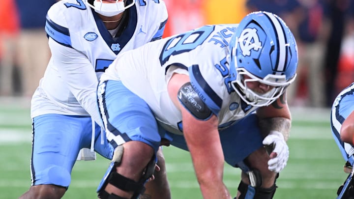 Oct 31, 2025; Syracuse, New York, USA; North Carolina Tar Heels quarterback Gio Lopez (7) with center Austin Blaske (58) at the line of scrimmage in the third quarter against the Syracuse Orange at the JMA Wireless Dome. 