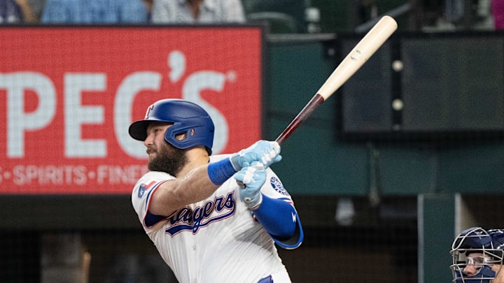 Texas Rangers first baseman Jake Burger swings through a baseball with his bat.
