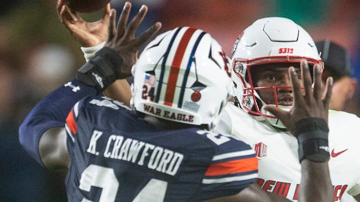 New Mexico Lobos quarterback Devon Dampier (4) throws the ball under pressure from Auburn Tigers defensive lineman Keyron Crawford (24) as Auburn Tigers take on New Mexico Lobos at Jordan-Hare Stadium in Auburn, Ala., on Saturday, Sept. 14, 2024.