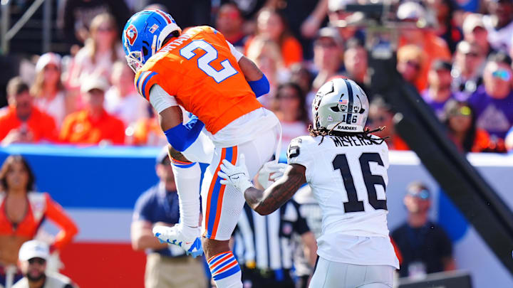 Oct 6, 2024; Denver, Colorado, USA; Denver Broncos cornerback Pat Surtain II (2) pulls in a interception intended for Las Vegas Raiders wide receiver Jakobi Meyers (16) in the second quarter at Empower Field at Mile High. 