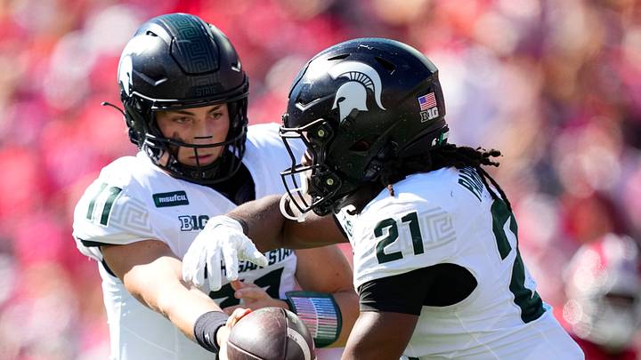 Oct 3, 2026; Madison, Wisconsin, USA; Michigan State Spartans quarterback Alessio Milivojevic (11) hands the football off to running back Marvis Parrish (21) during the second quarter at Camp Randall Stadium. Mandatory Credit: Jeff Hanisch-Imagn Images Oct 3, 2026; Madison, Wisconsin, USA; Michigan State Spartans quarterback Alessio Milivojevic (11) hands the football off to running back Marvis Parrish (21) during the second quarter at Camp Randall Stadium. Mandatory Credit: Jeff Hanisch-Imagn Images