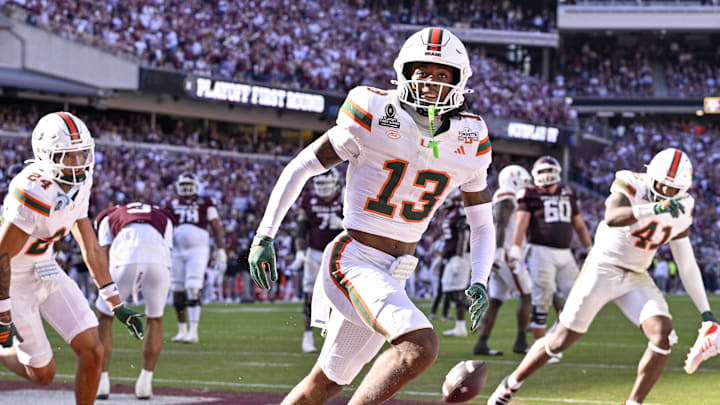 Dec 20, 2025; College Station, TX, USA; Miami Hurricanes defensive back Ethan O'Connor (24) and linebacker Chase Smith (41) and defensive back Bryce Fitzgerald (13) celebrate after Fitzgerald intercepts a Texas A&M Aggies pass in the end zone during the game between the Aggies and the Hurricanes at Kyle Field. Mandatory Credit: Jerome Miron-Imagn Images