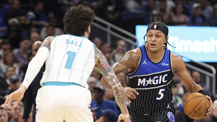 Jan 22, 2026; Orlando, Florida, USA; Orlando Magic forward Paolo Banchero (5) moves the ball past Charlotte Hornets guard LaMelo Ball (1) in the first quarter  at Kia Center. Mandatory Credit: Nathan Ray Seebeck-Imagn Images
