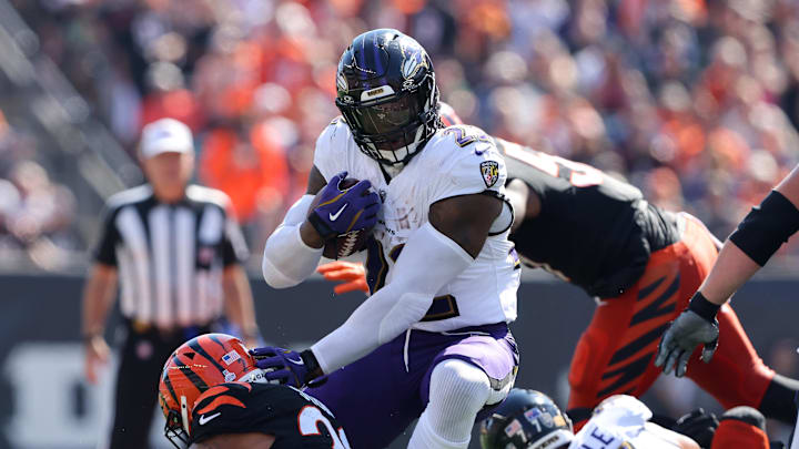 Baltimore Ravens running back Derrick Henry runs the ball past Cincinnati Bengals defenders.