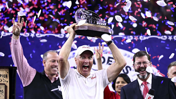 Houston Cougars head coach Willie Fritz hoists the champions trophy after the win over Louisiana State Tigers at NRG Stadium. 