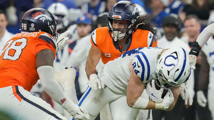 Denver Broncos defensive end John Franklin-Myers (98) and Denver Broncos safety Talanoa Hufanga (9) work to bring down Indianapolis Colts tight end Tyler Warren (84) on Sunday, Sept. 14, 2025, during a game against the Denver Broncos at Lucas Oil Stadium in Indianapolis.