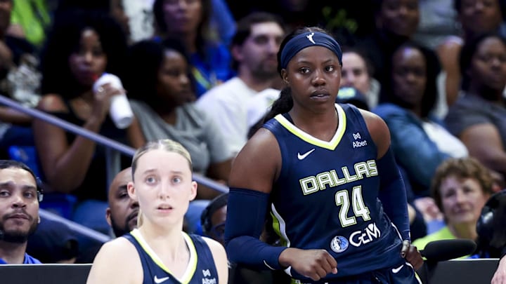 Dallas Wings guard Paige Bueckers and Dallas Wings guard Arike Ogunbowale wait to enter a game on the sidelines.