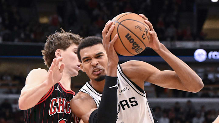 Nov 10, 2025; Chicago, Illinois, USA;  San Antonio Spurs forward Victor Wembanyama (1) drives to the basket against Chicago Bulls forward Matas Buzelis (14) and  guard Kevin Huerter (13) during the second half at the United Center. Mandatory Credit: Matt Marton-Imagn Images
