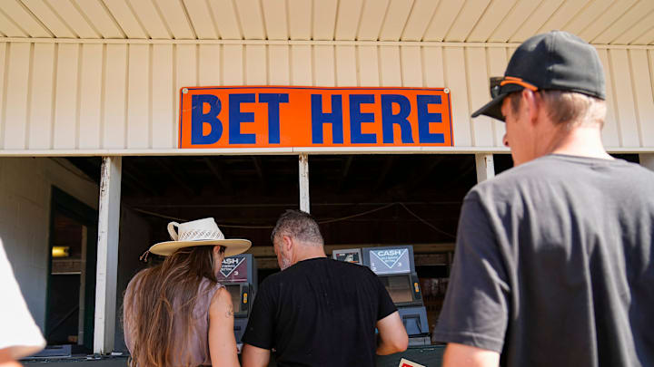 Spectators place bets during the 80th running of the Little Brown Jug harness racing event at the Delaware County Fairgrounds on Sept. 18, 2025.