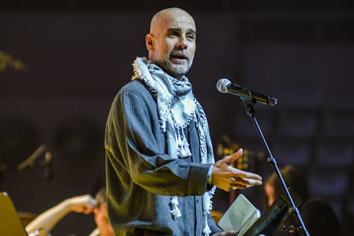 Pep Guardiola wearing a keffiyeh scarf.