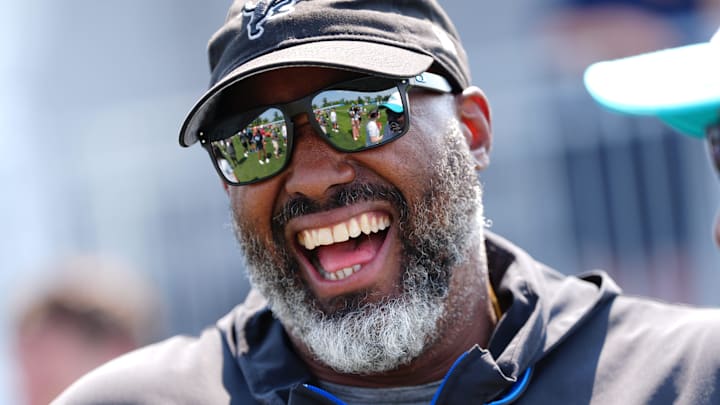 Detroit Lions executive vice president and general manager Brad Holmes laughs with Miami Dolphins coaches during a joint practice at the Lions headquarters and training facility in Allen Park, Thursday, Aug. 14, 2025.