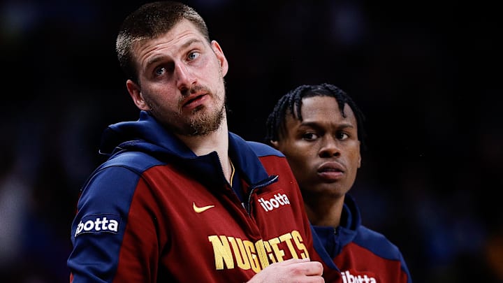 Apr 1, 2025; Denver, Colorado, USA; Denver Nuggets center Nikola Jokic (15) and forward Peyton Watson (8) look on from the sideline in the second quarter against the Minnesota Timberwolves at Ball Arena. Mandatory Credit: Isaiah J. Downing-Imagn Images