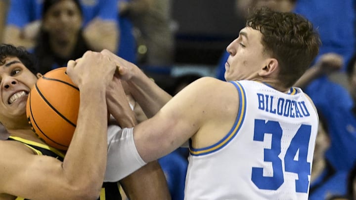 Jan 30, 2025; Los Angeles, California, USA;  Oregon Ducks forward Brandon Angel (21) battles for the ball against UCLA Bruins forward Tyler Bilodeau (34) in the first half at Pauley Pavilion presented by Wescom. Mandatory Credit: Alex Gallardo-Imagn Images