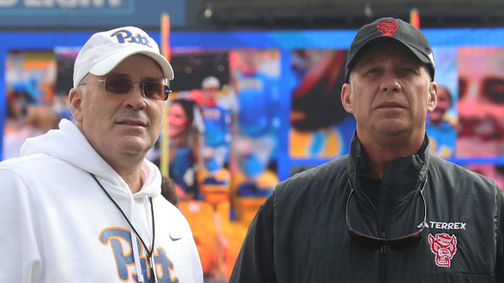 Oct 25, 2025; Pittsburgh, Pennsylvania, USA;  Pittsburgh Panthers head coach Pat Narduzzi (left) and North Carolina State Wolfpack head coach Dave Doeren (right) meet at midfield before their teams play at Acrisure Stadium. Mandatory Credit: Charles LeClaire-Imagn Images