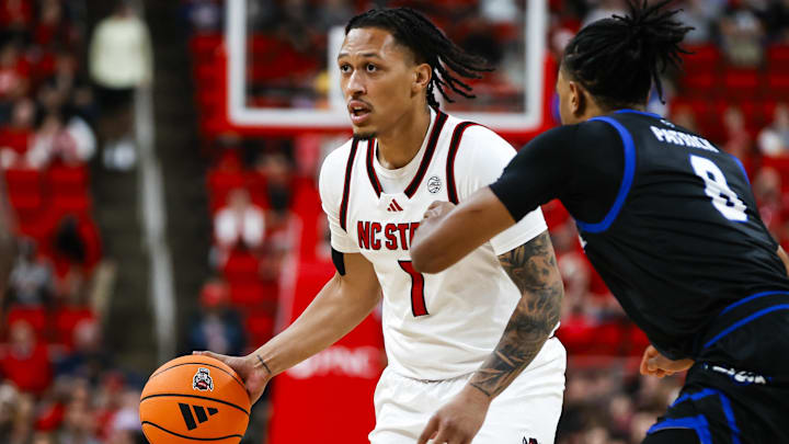 dDec 6, 2025; Raleigh, North Carolina, USA;  NC State Wolfpack forward Darrion Williams (1) dribbles the ball as UNC Asheville Bulldogs guard DJ Patrick (8) defends during the first half of the game at Lenovo Center. Mandatory Credit: Jaylynn Nash-Imagn Images