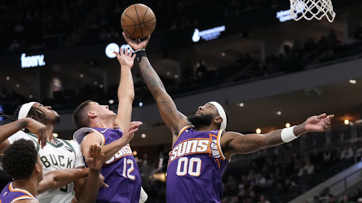 Mar 10, 2026; Milwaukee, Wisconsin, USA:  Phoenix Suns forward Royce O'Neale (00) reaches for a rebound during the first quarter against the Milwaukee Bucks at Fiserv Forum. Mandatory Credit: Jeff Hanisch-Imagn Images