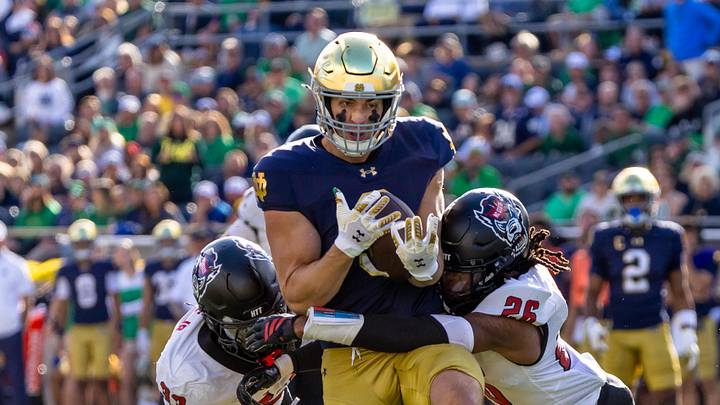 Oct 11, 2025; South Bend, Indiana, USA; Notre Dame Fighting Irish tight end Eli Raridon (9) competes a pass while NC State Wolfpack linebacker Jr. Kenny Soares (33) and defensive back Asaad Brown Jr. (26) tackle him during the first half at Notre Dame Stadium. Mandatory Credit: Michael Caterina-Imagn Images