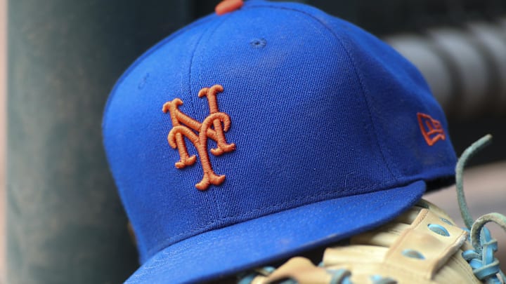 Jul 13, 2022; Atlanta, Georgia, USA; A detailed view of a New York Mets hat and glove in the dugout against the Atlanta Braves in the eighth inning at Truist Park. 