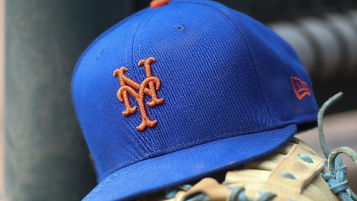 Jul 13, 2022; Atlanta, Georgia, USA; A detailed view of a New York Mets hat and glove in the dugout against the Atlanta Braves in the eighth inning at Truist Park. 