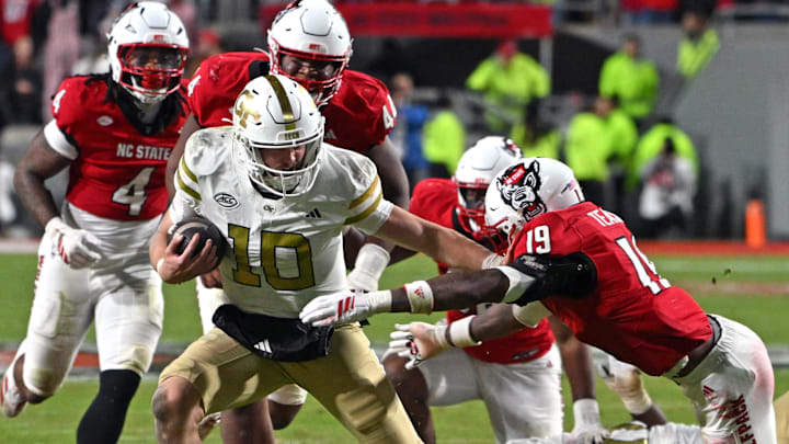 Nov 1, 2025; Raleigh, North Carolina, USA;  Georgia Tech Yellow Jackets quarterback Haynes King (10) controls the ball against North Carolina State Wolfpack safety Tristan Teasdell (19) during the fourth quarter at Carter-Finley Stadium. Mandatory Credit: Zachary Taft-Imagn Images