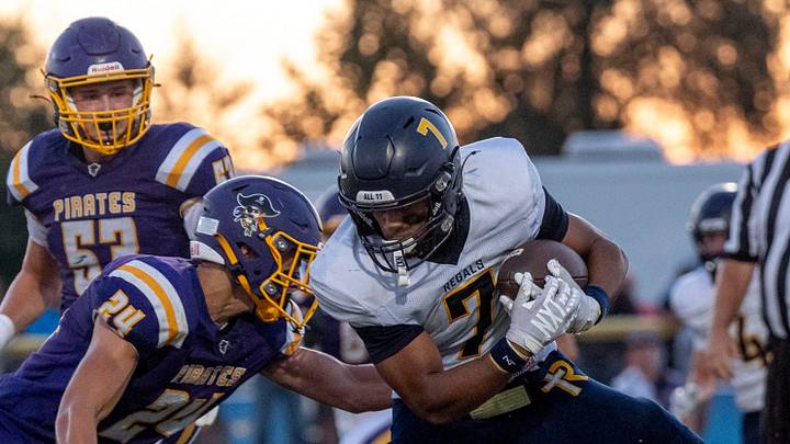 Alburnett’s Owen Henriksen (8) holds on to the ankle of Regina’s Gabriel Hegelheimer (7) as he carries the ball during a high school football game Sept. 10, 2026 in Alburnett, Iowa.