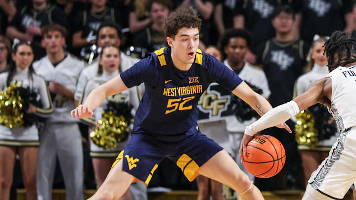 Feb 14, 2026; Orlando, Florida, USA; West Virginia Mountaineers guard Jasper Floyd (1) and guard Treysen Eaglestaff (52) defend UCF Knights guard Themus Fulks (1) during the first half at Addition Financial Arena. Mandatory Credit: Mike Watters-Imagn Images