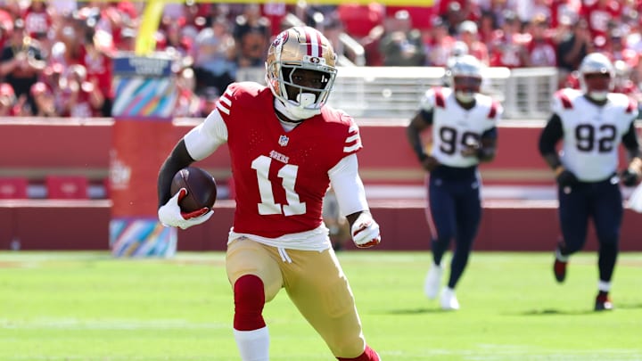 Sep 29, 2024; Santa Clara, California, USA; San Francisco 49ers wide receiver Brandon Aiyuk (11) runs with the ball past New England Patriots linebacker Jahlani Tavai (48) during the first quarter at Levi's Stadium. Mandatory Credit: Sergio Estrada-Imagn Images