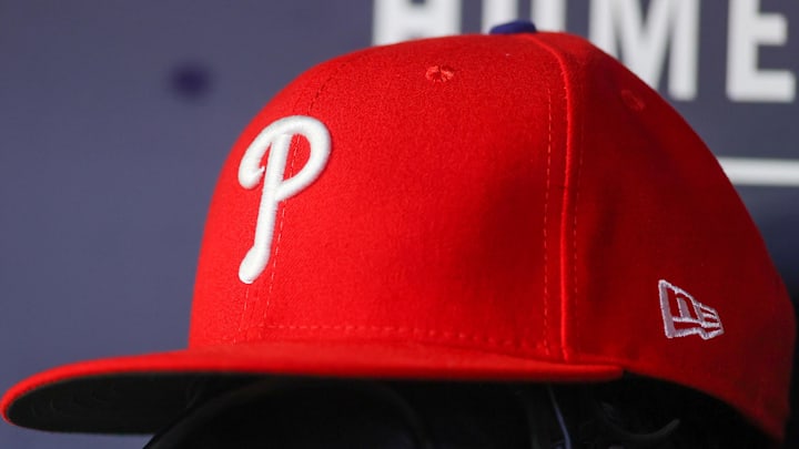 May 26, 2023; Atlanta, Georgia, USA; A detailed view of a Philadelphia Phillies hat and glove on the bench against the Atlanta Braves in the seventh inning at Truist Park. 