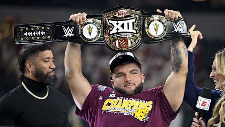 Dec 7, 2024; Arlington, TX, USA; Arizona State Sun Devils running back Cam Skattebo (4) holds up the WWE Big 12 championship belt after the Sun Devils defeat the Iowa State Cyclones and win the 2024 Big 12 Championship at AT&T Stadium. Mandatory Credit: Jerome Miron-Imagn Images Dec 7, 2024; Arlington, TX, USA; Arizona State Sun Devils running back Cam Skattebo (4) holds up the WWE Big 12 championship belt after the Sun Devils defeat the Iowa State Cyclones and win the 2024 Big 12 Championship at AT&T Stadium. Mandatory Credit: Jerome Miron-Imagn Images