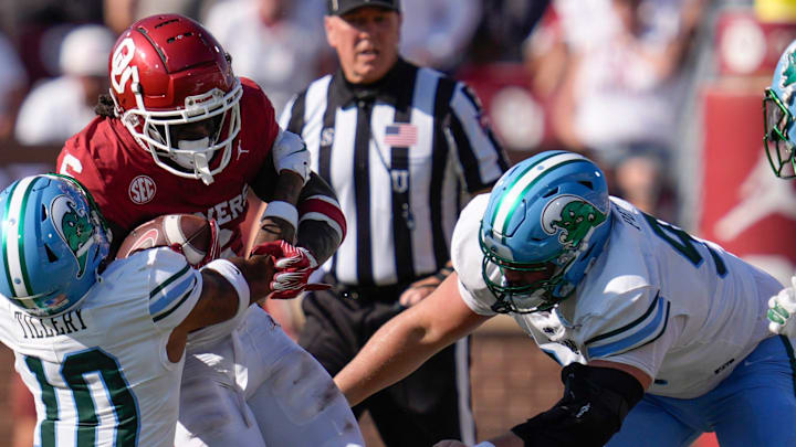 Oklahoma Sooners wide receiver Deion Burks (6) is brought down by Tulane Green Wave defensive back Lu Tillery (10) and Tulane Green Wave defensive end Parker Petersen (98) during a college football game between the University of Oklahoma Sooners (OU) and the Tulane Green Wave at Gaylord Family - Oklahoma Memorial Stadium in Norman, Okla., Saturday, Sept. 14, 2024.