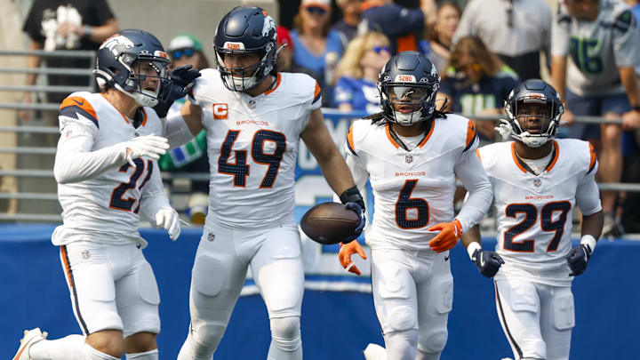 Sep 8, 2024; Seattle, Washington, USA; Denver Broncos linebacker Alex Singleton (49) celebrates with cornerback Riley Moss (21), safety P.J. Locke (6) and cornerback Ja'Quan McMillian (29) after intercepting a pass against the Seattle Seahawks during the first quarter at Lumen Field. 