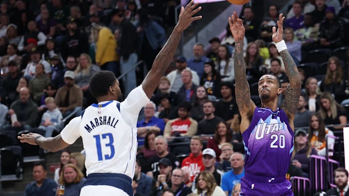 Nov 14, 2024; Salt Lake City, Utah, USA; Utah Jazz forward John Collins (20) takes a three point shot against Dallas Mavericks forward Naji Marshall (13) during the first quarter at Delta Center. Mandatory Credit: Rob Gray-Imagn Images